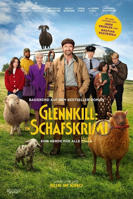Auf dem Plakat sind mehrere Menschen zu sehen, die auf einer grünen Wiese stehen. Im Hintergrund sieht man einen silbernen Wohnwagen, auf welchem ein schwarzes Schaf steht. Auf der Wiese stehen ebenfalls zwei Schafe und ein kleines Lamm.